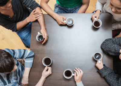 people sitting around table drinking coffee talking smk